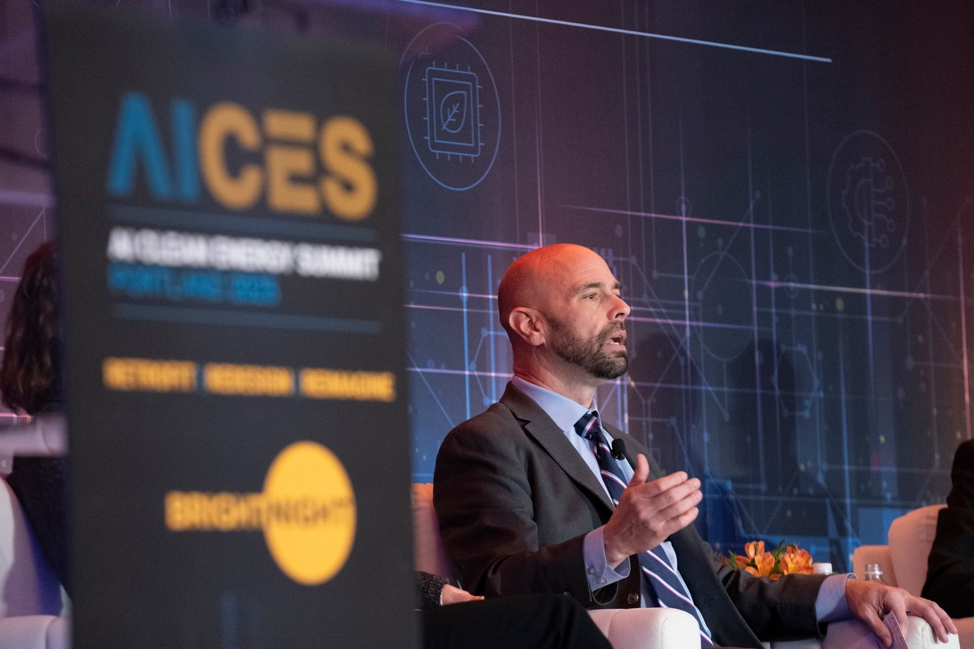 Keynote speaker on stage with dramatic lighting captured by MAGNIFY Photo videography team